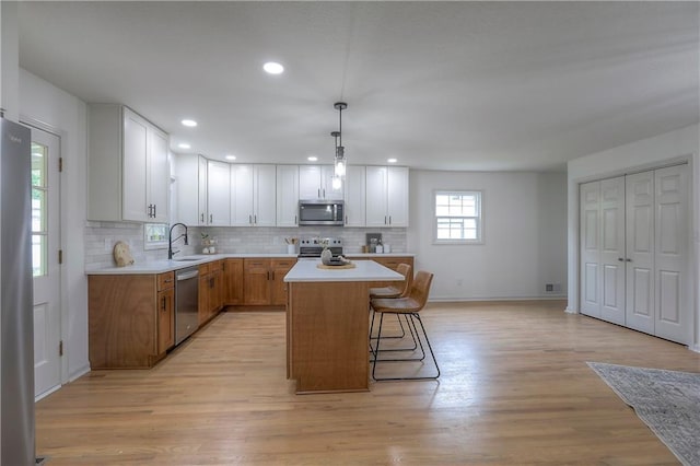 kitchen featuring light countertops, tasteful backsplash, a kitchen island, and stainless steel appliances