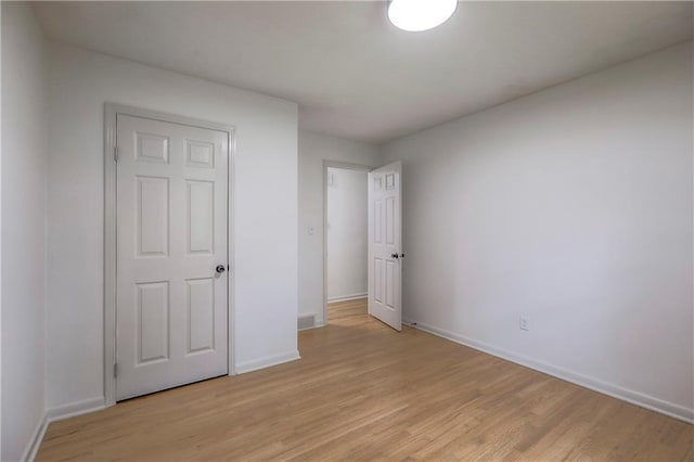 unfurnished bedroom with baseboards and light wood-style floors