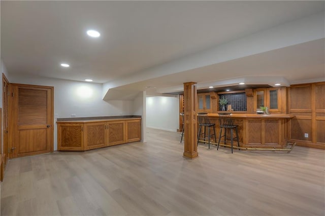 finished basement with recessed lighting, wet bar, baseboards, and light wood finished floors