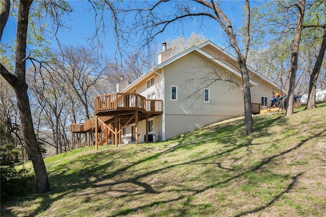 23801 Evans Rd, Tonganoxie, KS 66086 - rear view of property with a wooden deck, a chimney, stairs, and a lawn