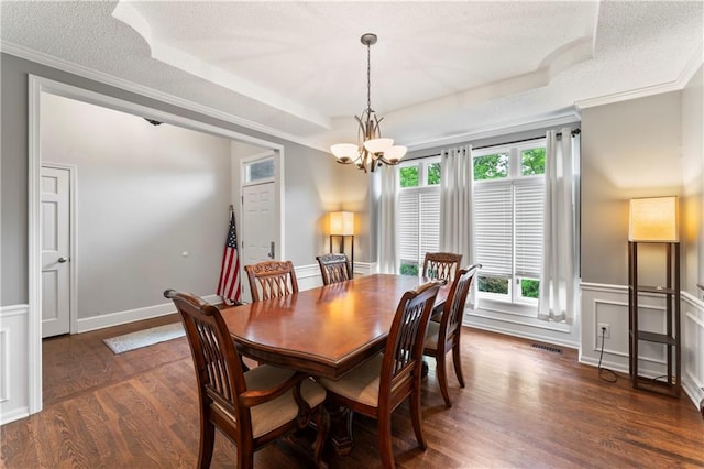 4504 NE 60th Ter, Kansas City, MO 64119 - dining room with crown molding, dark wood-style flooring, a textured ceiling, a tray ceiling, and a notable chandelier