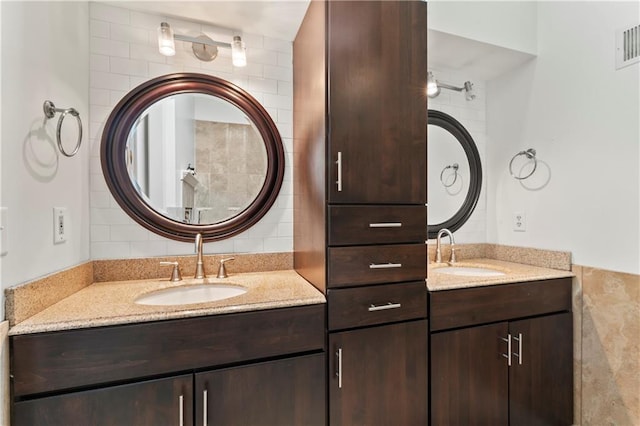 4504 NE 60th Ter, Kansas City, MO 64119 - bathroom featuring visible vents, two vanities, a sink, and tasteful backsplash