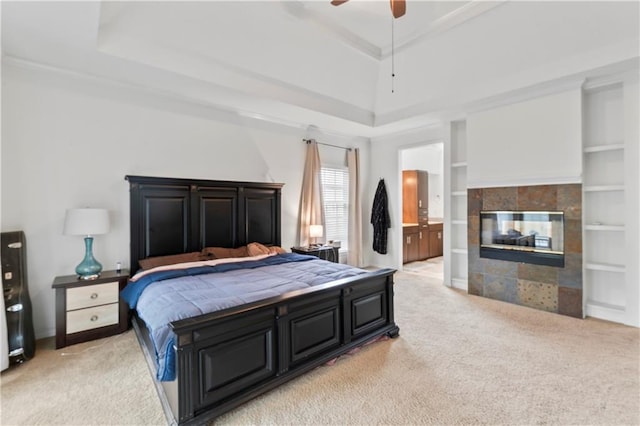 4504 NE 60th Ter, Kansas City, MO 64119 - bedroom featuring a fireplace, a tray ceiling, and light colored carpet