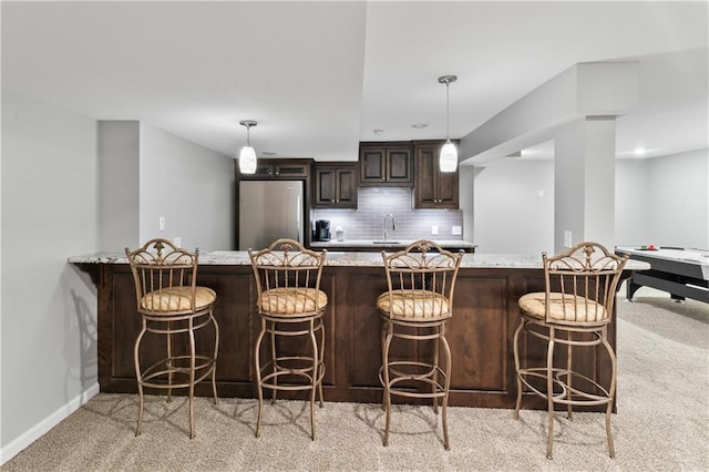4504 NE 60th Ter, Kansas City, MO 64119 - kitchen with dark brown cabinetry, light colored carpet, a sink, freestanding refrigerator, and baseboards