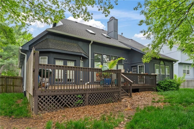4504 NE 60th Ter, Kansas City, MO 64119 - rear view of house with a shingled roof, fence, a wooden deck, and a chimney