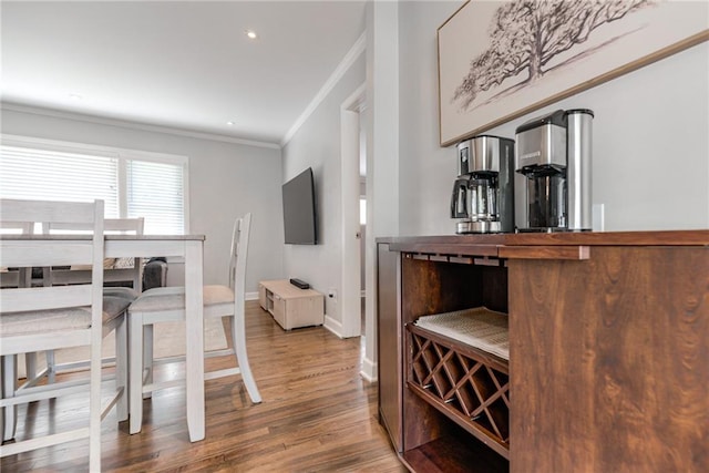 dining space with crown molding, recessed lighting, baseboards, and wood finished floors