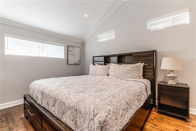 bedroom with baseboards, ornamental molding, wood finished floors, and lofted ceiling
