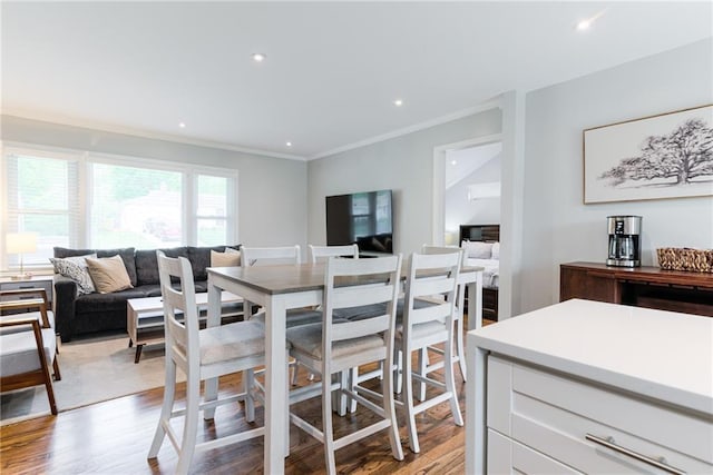 dining space with ornamental molding, recessed lighting, and light wood-style flooring