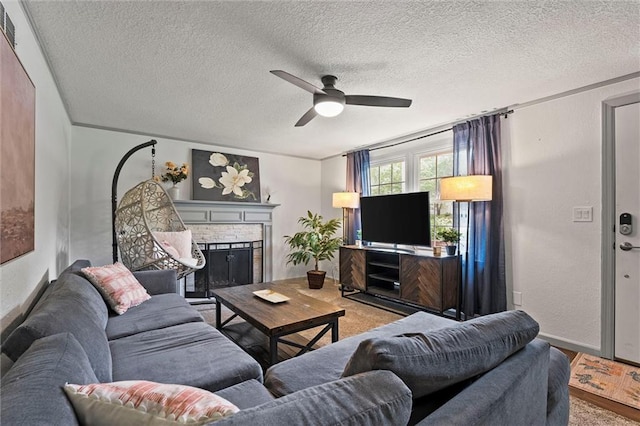 living area with baseboards, a ceiling fan, a textured ceiling, and a fireplace