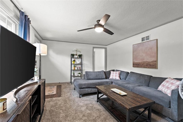 carpeted living area featuring visible vents, a textured ceiling, and ceiling fan