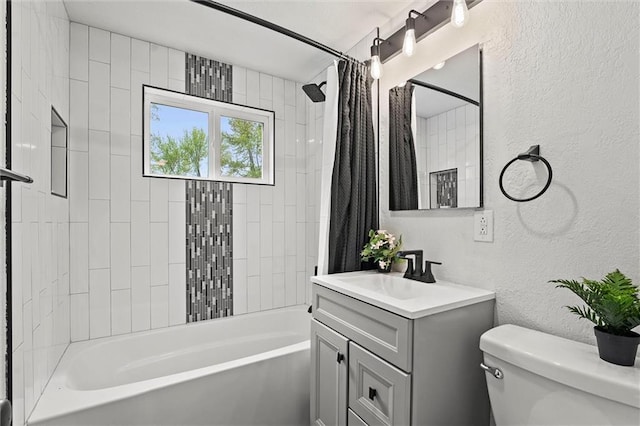 bathroom with vanity, toilet, a textured wall, and shower / tub combo