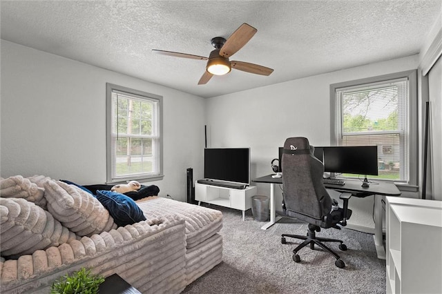 carpeted home office with a ceiling fan and a textured ceiling
