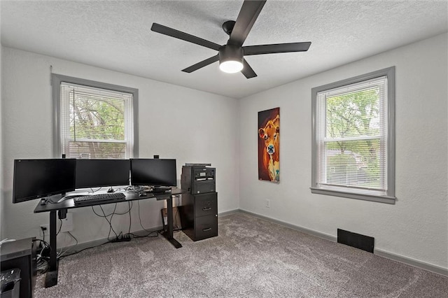 carpeted office featuring baseboards, ceiling fan, a textured ceiling, and visible vents