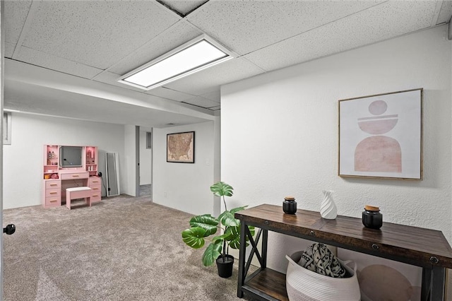 interior space with a paneled ceiling and carpet