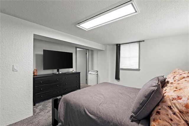 bedroom with carpet flooring, a textured ceiling, a textured wall, and a closet