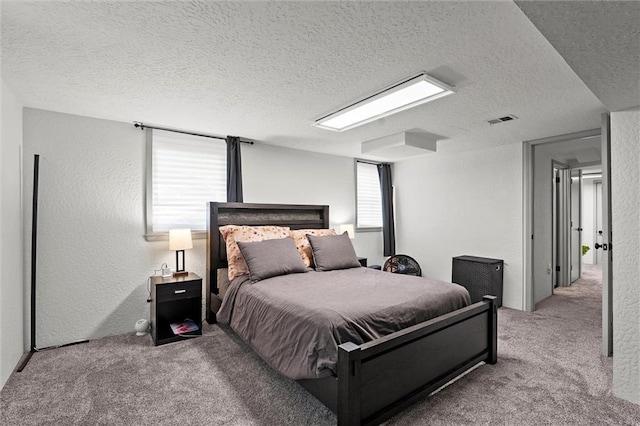 bedroom featuring visible vents, a textured ceiling, and carpet