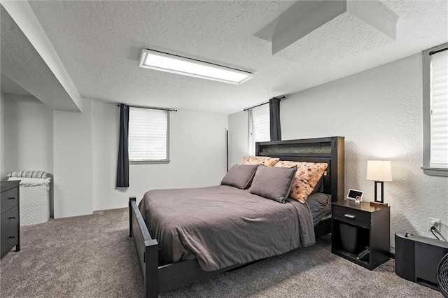 bedroom with multiple windows, carpet flooring, and a textured ceiling