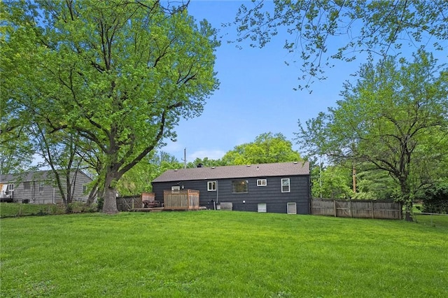 rear view of house featuring a yard, a deck, and fence