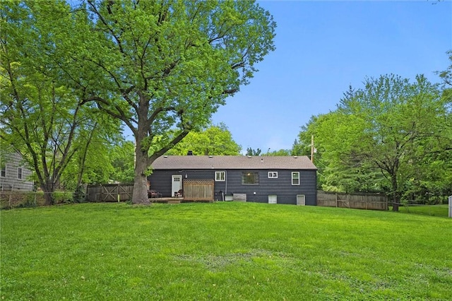 back of house featuring a lawn and fence