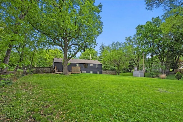 view of yard featuring a storage shed, an outdoor structure, and a fenced backyard