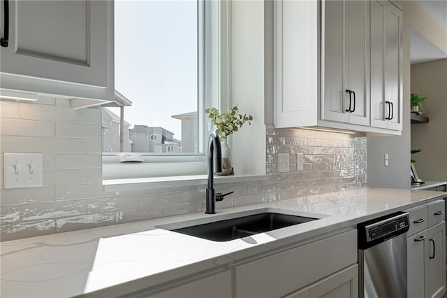 kitchen with backsplash, a sink, and dishwasher