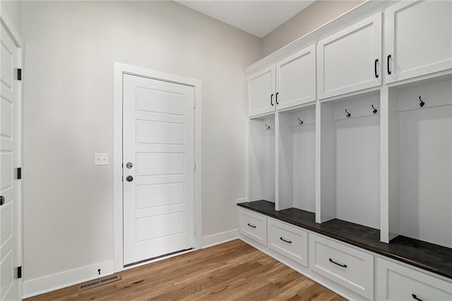 mudroom with light wood finished floors, visible vents, and baseboards