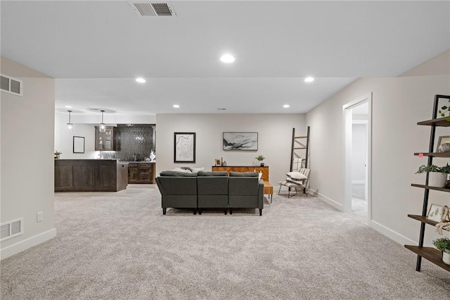carpeted living area featuring visible vents, baseboards, and recessed lighting
