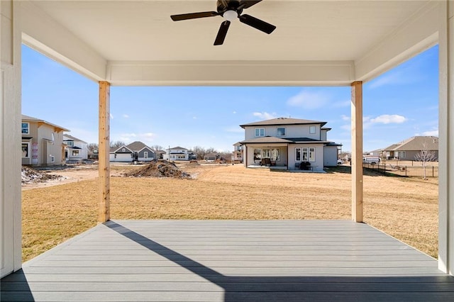 wooden terrace featuring a patio area, a residential view, a lawn, and ceiling fan