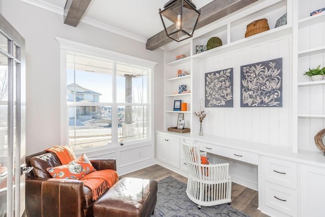 office area featuring built in study area, crown molding, built in shelves, and wood finished floors