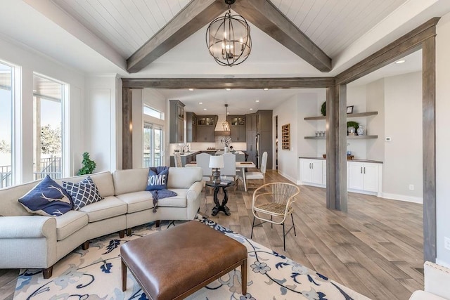 living room featuring light wood-type flooring, baseboards, built in features, beamed ceiling, and a notable chandelier