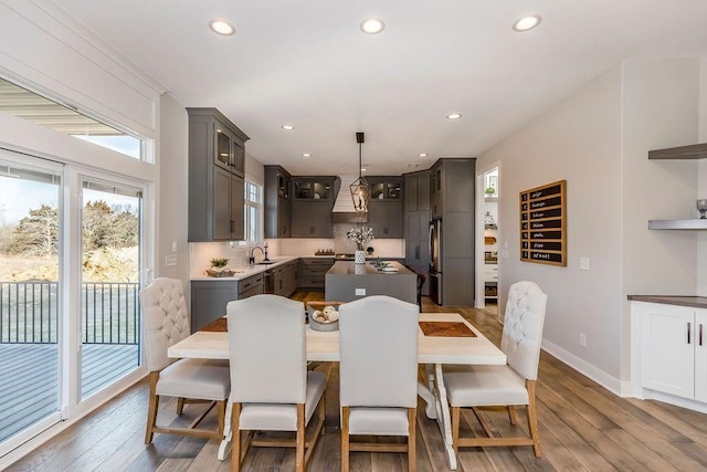 dining room with wood finished floors, baseboards, and recessed lighting