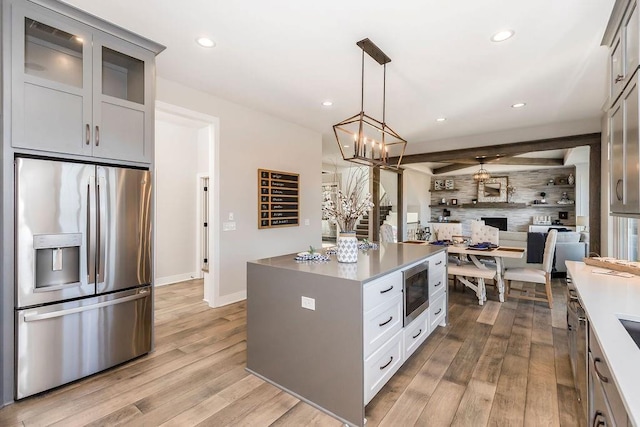 kitchen with stainless steel appliances, open floor plan, light wood-style flooring, and recessed lighting