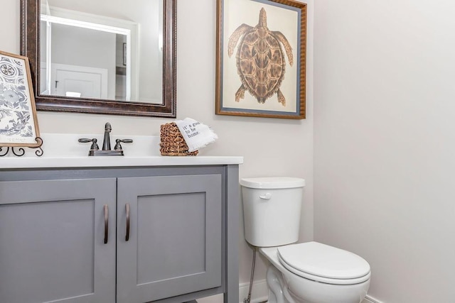 bathroom featuring vanity, toilet, and baseboards
