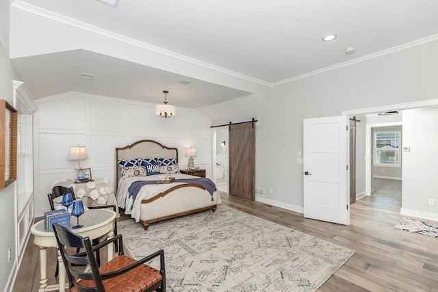 bedroom with light wood-style flooring, recessed lighting, a barn door, baseboards, and ornamental molding