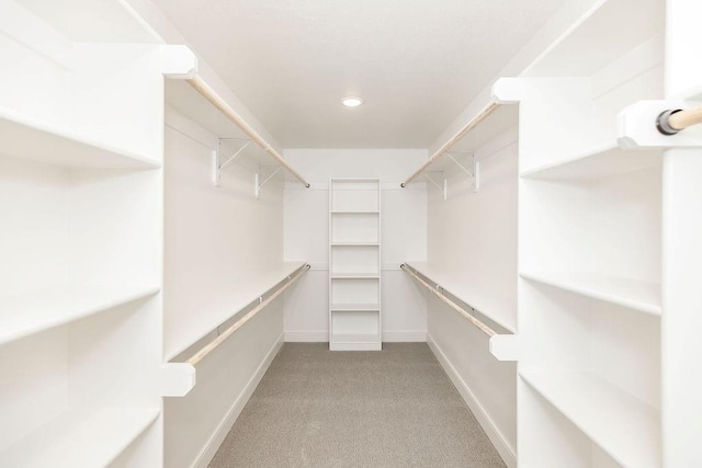 walk in closet featuring light colored carpet