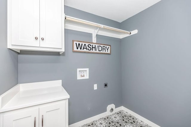 washroom with electric dryer hookup, cabinet space, washer hookup, baseboards, and tile patterned flooring