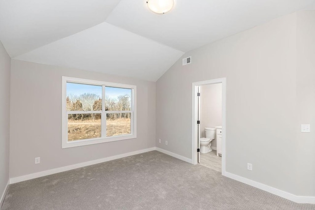 unfurnished bedroom featuring carpet, baseboards, ensuite bathroom, visible vents, and vaulted ceiling