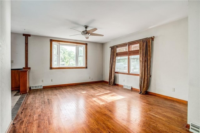 2806 S Whitney Ave, Independence, MO 64057 - unfurnished living room featuring a ceiling fan, wood finished floors, and baseboards