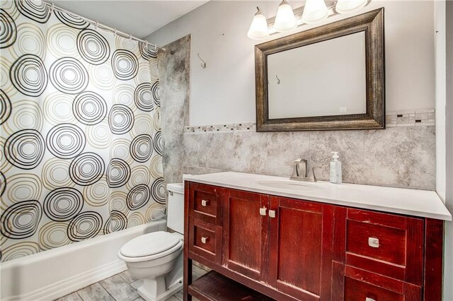 2806 S Whitney Ave, Independence, MO 64057 - bathroom with tile walls, toilet, vanity, shower / bathtub combination with curtain, and wainscoting