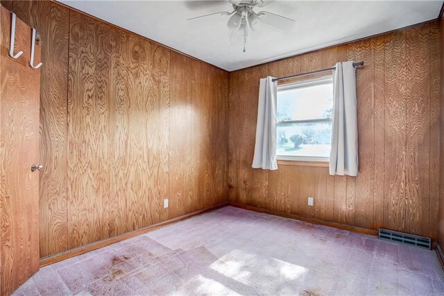 2806 S Whitney Ave, Independence, MO 64057 - carpeted empty room featuring a ceiling fan, wood walls, and baseboards