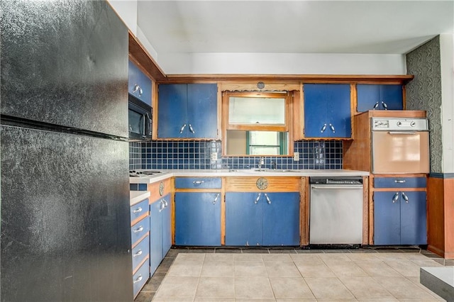 2806 S Whitney Ave, Independence, MO 64057 - kitchen with black appliances, tasteful backsplash, blue cabinetry, light countertops, and light tile patterned floors