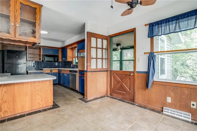 2806 S Whitney Ave, Independence, MO 64057 - kitchen featuring a ceiling fan, black appliances, plenty of natural light, wainscoting, and wood walls