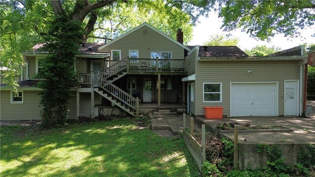 2806 S Whitney Ave, Independence, MO 64057 - rear view of house featuring stairs, a wooden deck, driveway, a lawn, and a garage