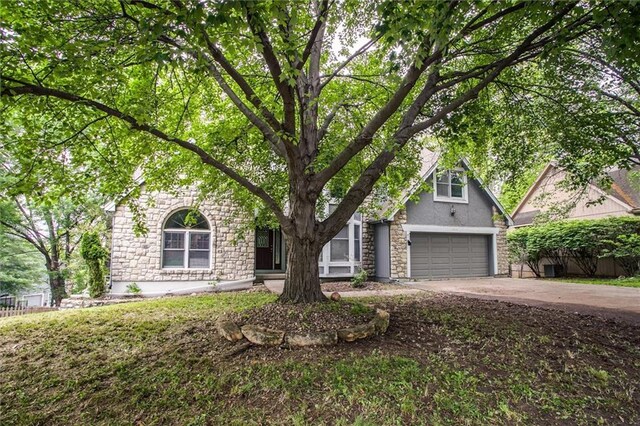 4008 NW 75th St, Kansas City, MO 64151 - view of front of house featuring an attached garage, driveway, stone siding, and stucco siding