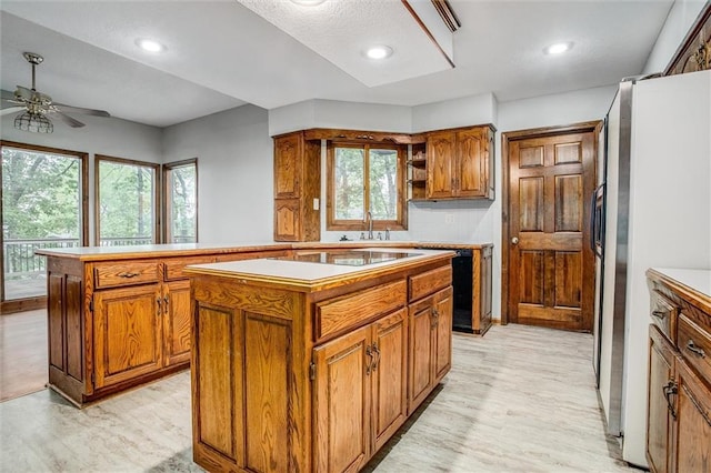4008 NW 75th St, Kansas City, MO 64151 - kitchen featuring freestanding refrigerator, brown cabinetry, a center island, ceiling fan, and recessed lighting