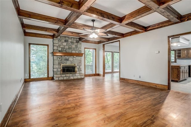 4008 NW 75th St, Kansas City, MO 64151 - unfurnished living room with light wood-style floors, baseboards, plenty of natural light, beamed ceiling, and coffered ceiling
