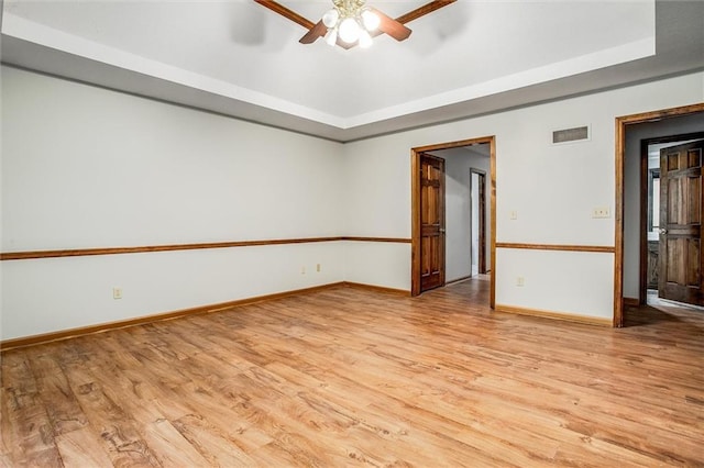 4008 NW 75th St, Kansas City, MO 64151 - spare room featuring a raised ceiling, light wood-style floors, a ceiling fan, and baseboards