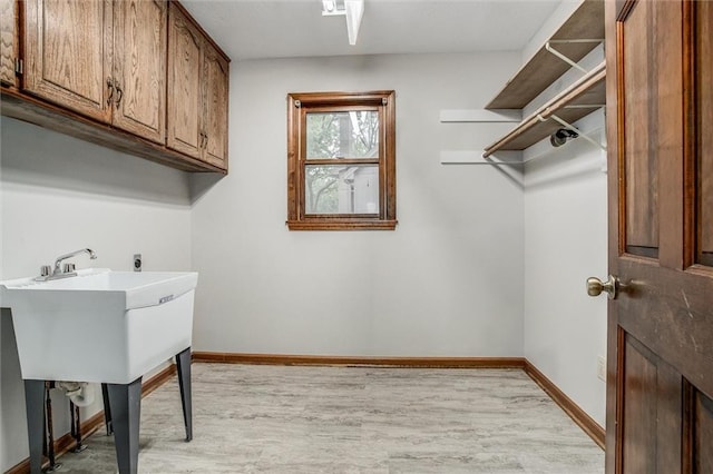 4008 NW 75th St, Kansas City, MO 64151 - laundry area featuring cabinet space, light wood-type flooring, and baseboards