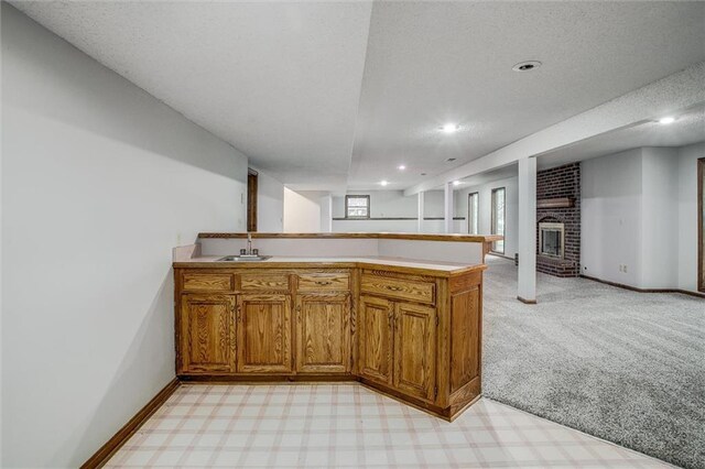 4008 NW 75th St, Kansas City, MO 64151 - kitchen with a peninsula, brown cabinets, light carpet, a sink, and recessed lighting