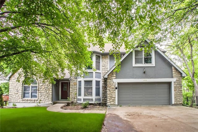 4008 NW 75th St, Kansas City, MO 64151 - tudor-style house with stucco siding, stone siding, concrete driveway, an attached garage, and a front lawn